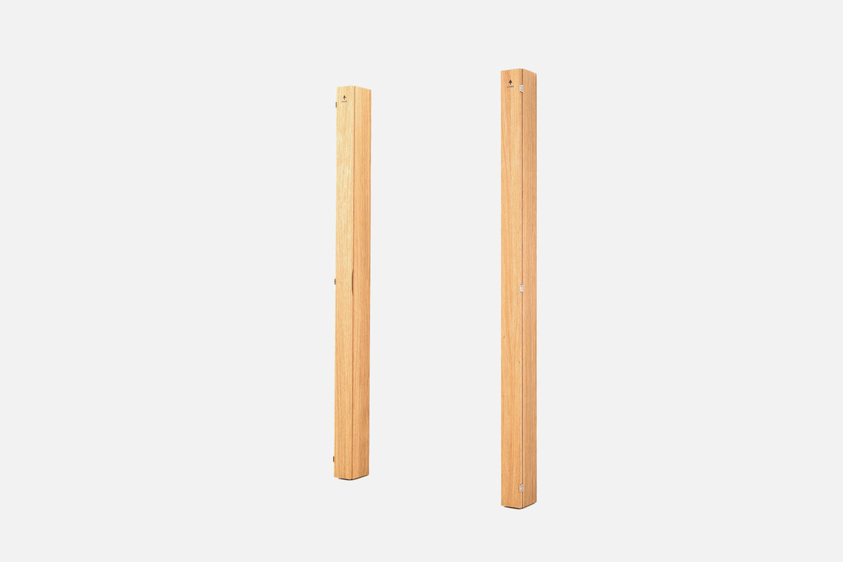 Two folded pale-oak wall racks standing upright, with silver hinges along the seam