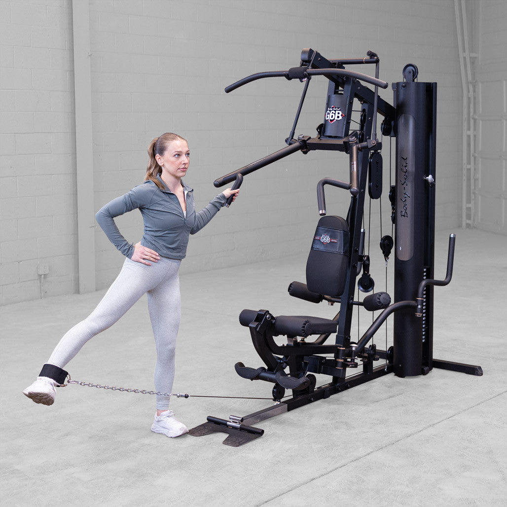 Body-Solid G6B gym in use with standing leg extension