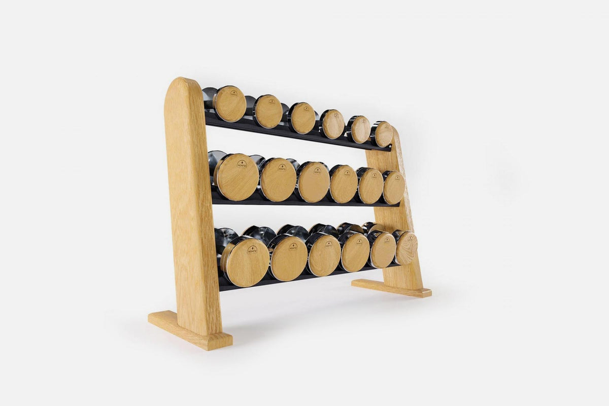 Three-tier pale oak rack holding nine pairs of nickel-plated dumbbells with light wood end caps