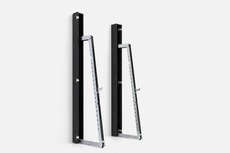 Two wall-mounted squat racks in black wood, one folded shut and one opened to a silver ladder